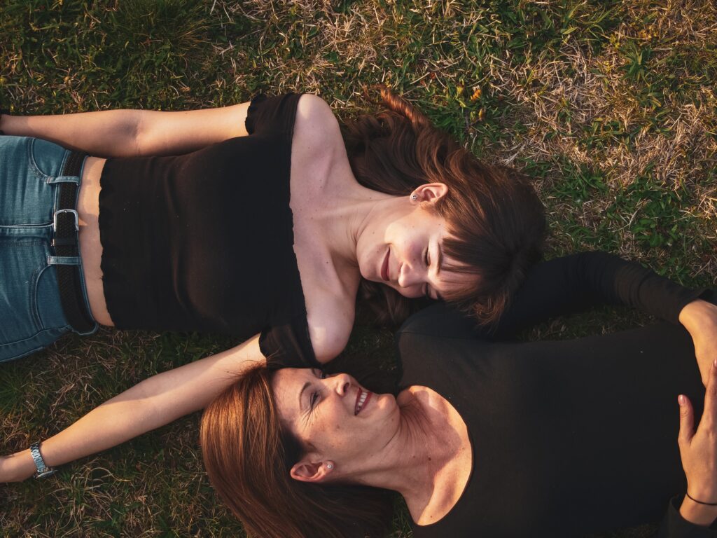 Women lying on grass field