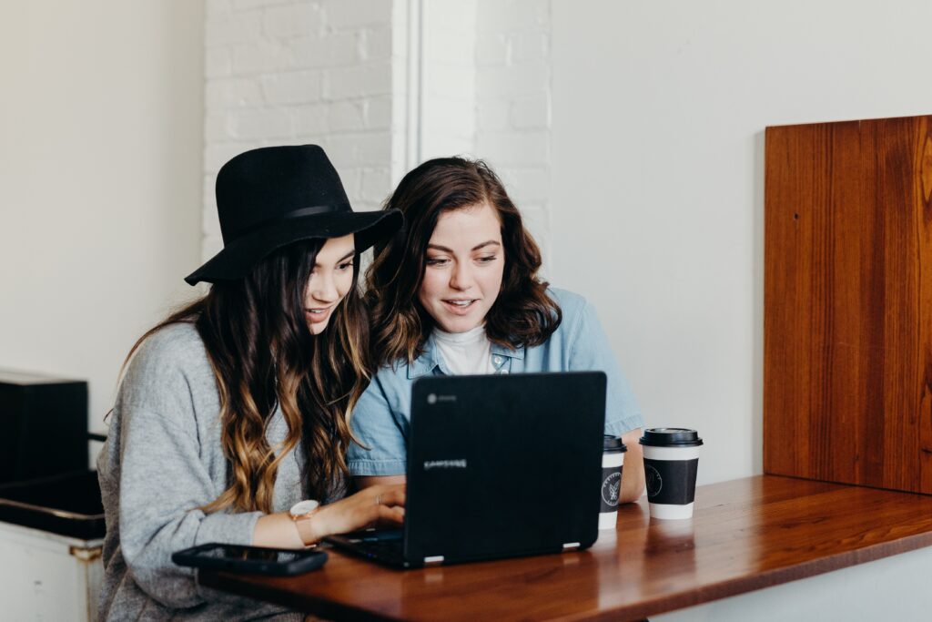 Two girls looking at same screen