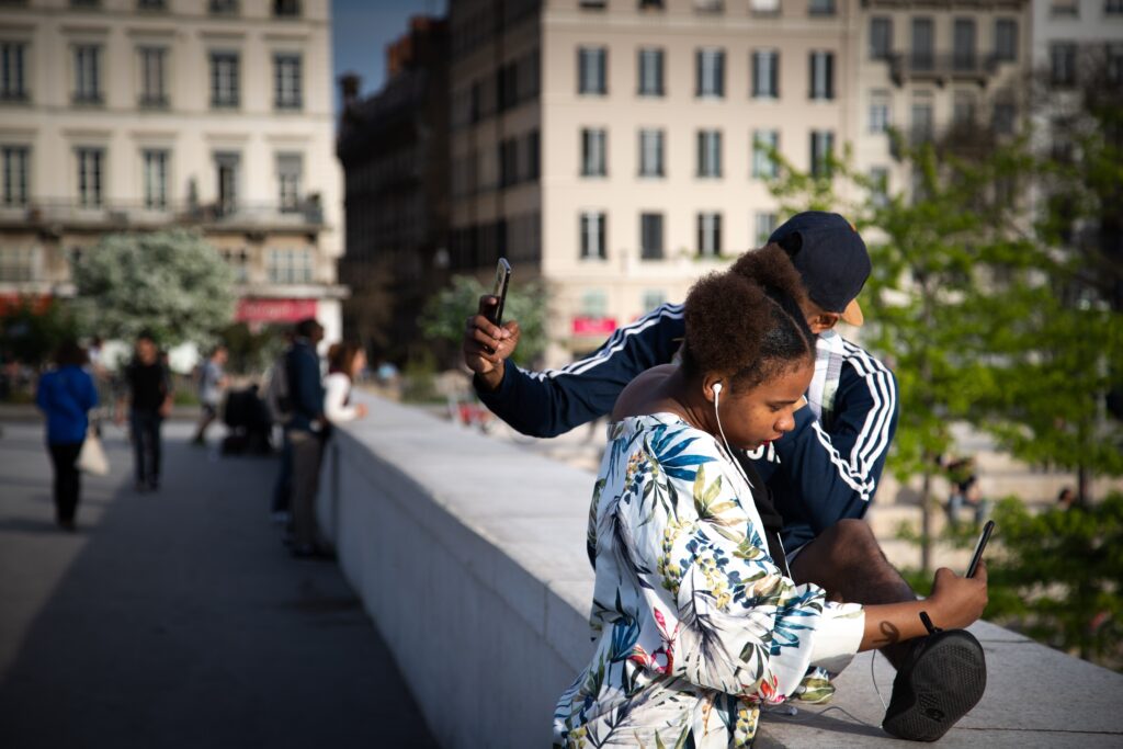 Boy and girl taking selfies with their phones